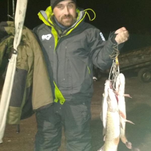 Фото пойманой щуки вечером в руках рыбака